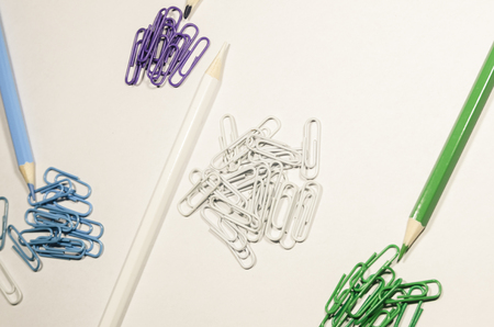 Paperclips and a pencil of one color isolated on white background. Be creative concept. School supplies or stuff. Education or business background.の写真素材