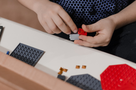 Toy bricks for kids in the hands of a little boy. Playing and building with plastic toy bricks concept. Pieces and elements of constructor toys. Be creative and different.の写真素材
