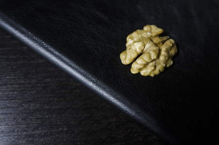 A piece of peeled walnut on the black table background. Healthy organic food ingridients close up view.の写真素材