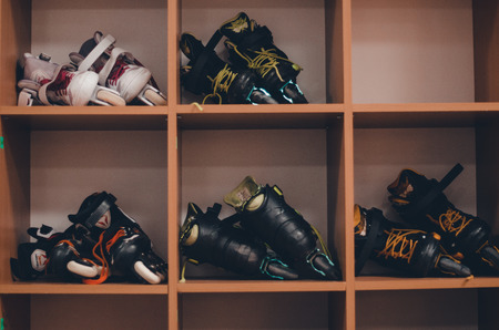 Pairs of black and white roller skates on the wooden shelves. Skating conept. Sport equipment close up view.の写真素材