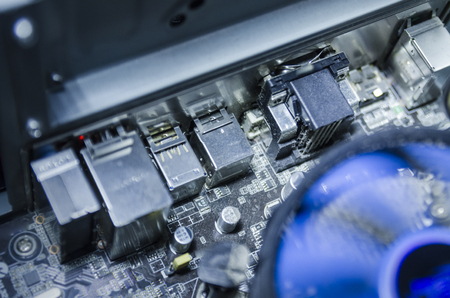Open computer power supply unit with dust on radio components. Colored wires. Selective focus....