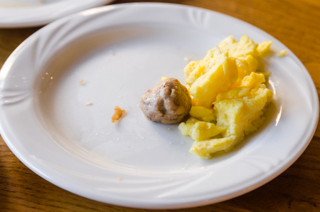 A white plate with food and a a white cup are on the wooden table. Ready to eat concept. Tasty food close up.の写真素材