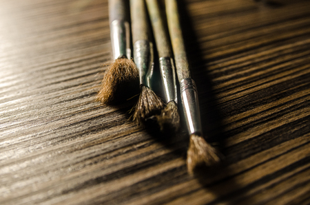 A collection of paint brushes on the wooden background. Art equipment for drawing.の写真素材