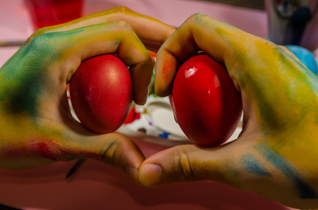 painter hands making a heart with easter eggs concept. Love Easter background. Be creative in drawing. Traditions for the holiday of Easter.の写真素材