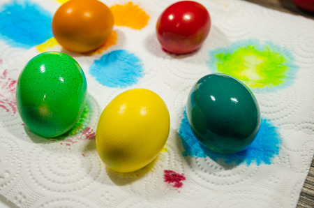 colored easter eggs drying on a white napkin concept. Happy Easter background. The process of...