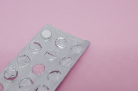 One pill left in the packing. Medicine concept isolated on the pink background. Cure your pain with...
