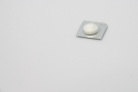 One white pill in packing. Medicine concept isolated on the white background. Cure your pain with capsules treatment. Done with taking tabletssの写真素材