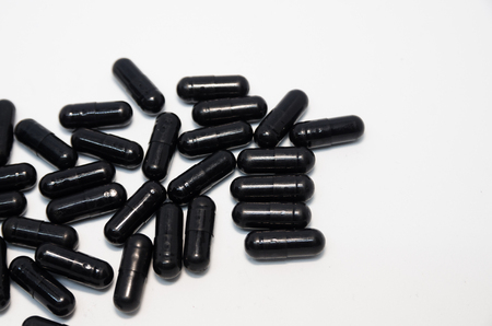 Medical black pills  with copy space. Medicine concept isolated on the white background. Cure your pain with capsules treatment. Stay healthyの写真素材
