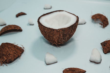 Ripe coconut composition background. A half of fresh coconut with little pieces of it. White exotic fruit close upの写真素材