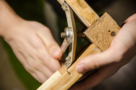 A man repairing one old wooden table at home. Repair or overhaul background. tighten the screw-nut with wrench tool concept.の写真素材