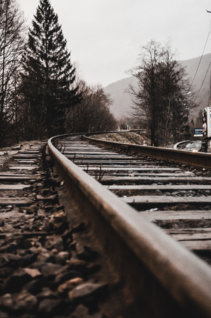 rails in foggy weather in the morning concept. Trees and mountain are on the background. Empty railroad track going into the fog.の写真素材