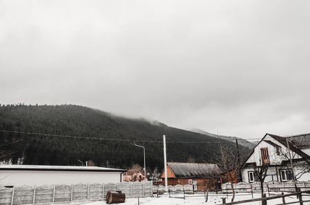 winter mountains over houses roofs covered with snow background. Ski resort in Ukraine, Bukovelの写真素材