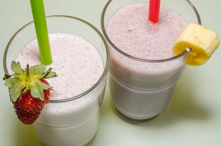 two milkshakes with banana and strawberryの写真素材