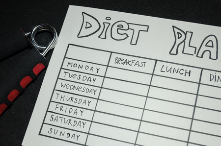 black background of blank nutrition plan with copy space for each day of the week. Diet food and loosing weight control concept.の写真素材