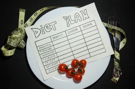 black background of blank nutrition plan with copy space and measuring tape. Diet food and loosing weight control concept.の写真素材