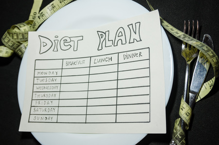 black background of blank nutrition plan with copy space and measuring tape. Diet food and loosing weight control concept.の写真素材