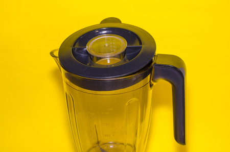 empty glass blender with a cover on yellow backgroundの写真素材
