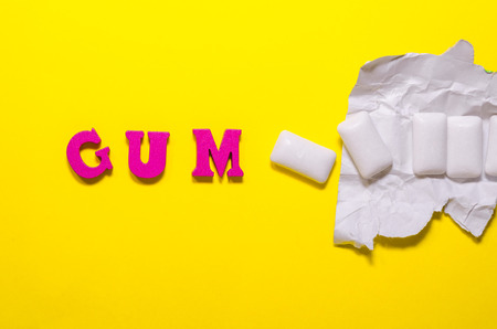 word gum compossed with wooden pink letters. white pads of chewing gumの写真素材