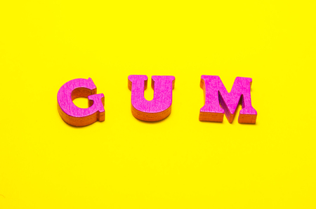 word gum compossed with wooden pink letters. white pads of chewing gumの写真素材