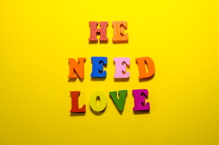 he needs love written with wooden colored lettersの写真素材