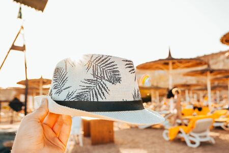 male panama hat with palm leaves and sunny beachの写真素材