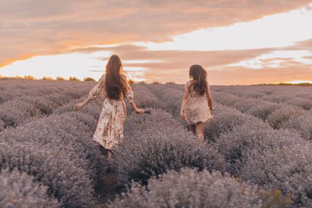 women running in the lavender field. two girls and gay pride conceptの写真素材