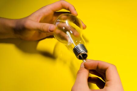 hands cleaning light bulb with cotton ear swab. diy with empty light bulbの写真素材