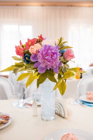 a bouquet of flowers in vase on served tables at the wedding. banquet conceptの写真素材