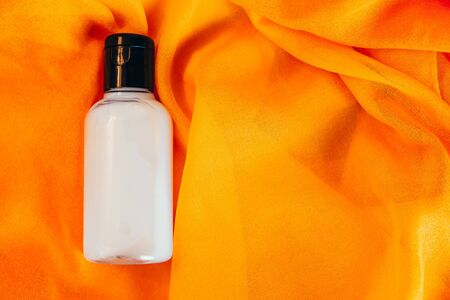 body lotion in travel bottle on orange backgroundの写真素材