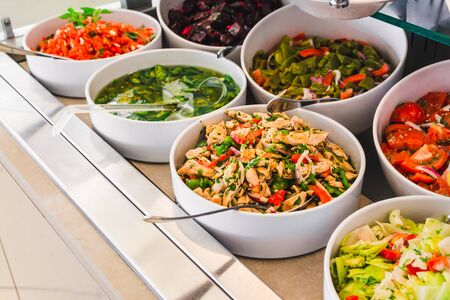 close up view of buffet table with salats and  vegetables in big white plates. hotel dinning roomの写真素材