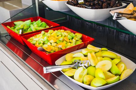 fresh cut fruits on the plates on buffet table. hotel dinning roomの写真素材