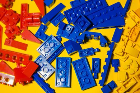 colored toy bricks for kids on the floor background. Playing in plastic pieces and elements of constructor toys conceptの写真素材