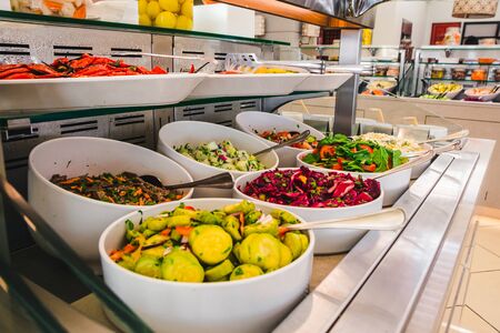 close up view of buffet table with salats and  vegetables in big white plates. hotel dinning roomの写真素材