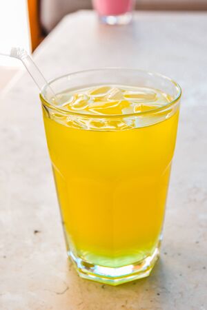 an orange lemonade in glass cup on the tableの写真素材