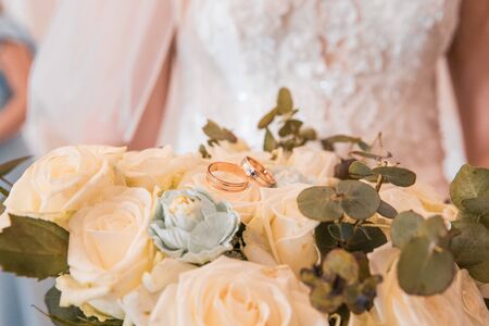 wedding rings lie on the bouquet of flowersの写真素材