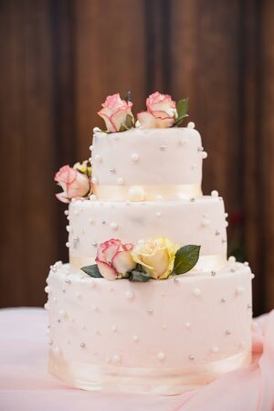 three story wedding cake with flowers on tableの写真素材