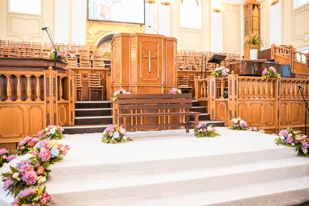wooden altar at wedding in church decorated with flowersの写真素材