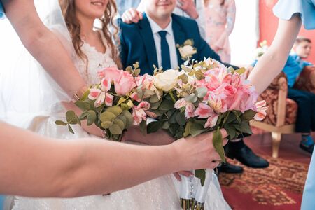 flower bouquets at wedding day in front of smiling bride and groomの写真素材