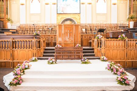 wooden altar at wedding in church decorated with flowersの写真素材