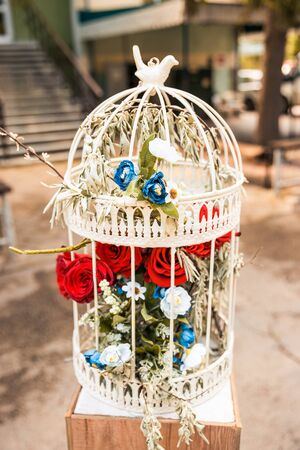 red roses with blue flowers in white cage. wedding decorの写真素材