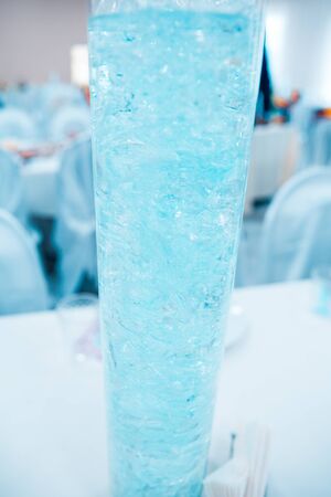 glass vase with blue water on the tableの写真素材
