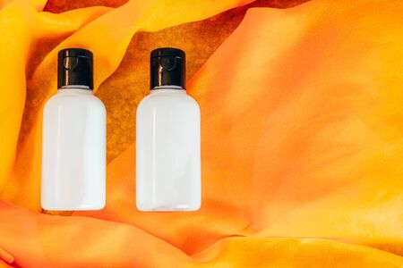 body lotion and shower gel in travel bottle on orange backgroundの写真素材