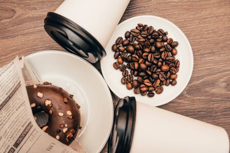 background of takeaway coffee cups with chocolate donut on the wooden table. breakfast at the coffee shop conceptの写真素材