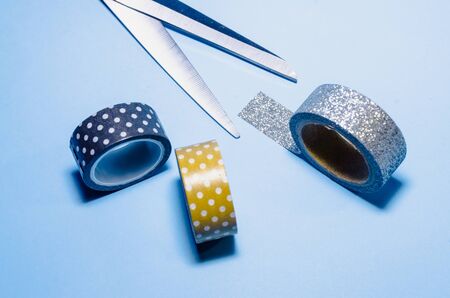 colorful washi tapes with scissors isolated on blue background from top viewの写真素材