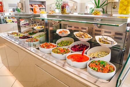 background of buffet table with salats and  vegetables in big white plates. hotel dinning roomの写真素材