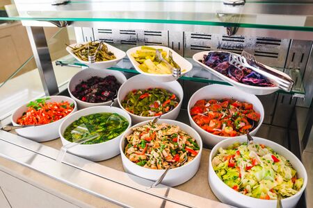 close up view of buffet table with salats and  vegetables in big white plates. hotel dinning roomの写真素材