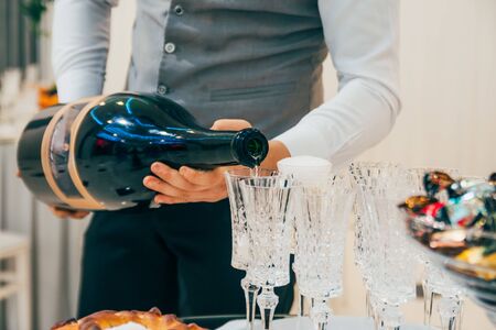 waiter pours champagne into wine glasses on the weddingの写真素材