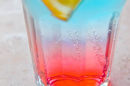 close up of pink and blue cooling drink with slices of orangeの写真素材
