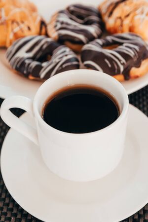 cup of coffee and donuts with chocolate topping for breakfast.の写真素材