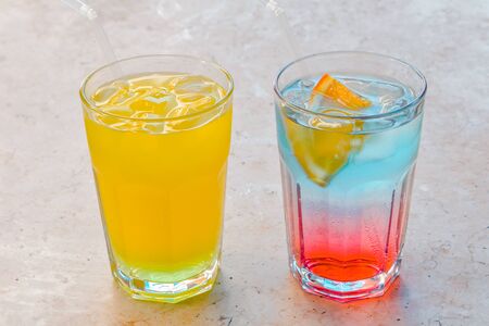 two cooling drinks with ice cubes from the crop view. lemonade and pink and blue cocktailの写真素材